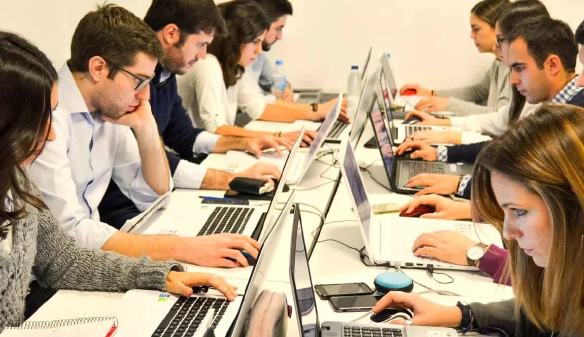 Alumnos trabajando con sus portátiles en una clase de IDESIE