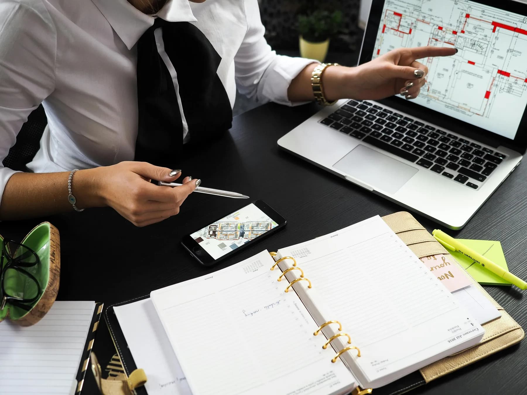 Manos de un equipo revisando planos y datos en una tableta