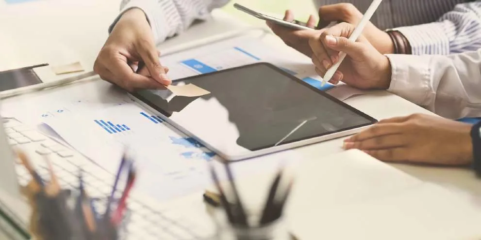 Manos de un equipo revisando datos en una tableta